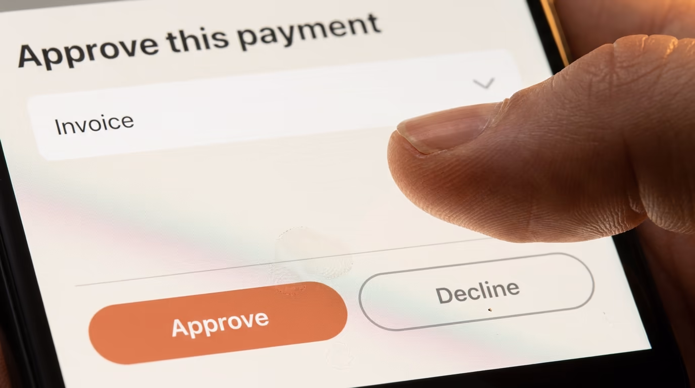 A thumb hovering over the Approve and Decline buttons on a Claude Duet payment approval screen